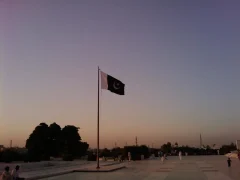 The national flag of Pakistan flying at Mazar-e-Quaid in Karachi at dusk