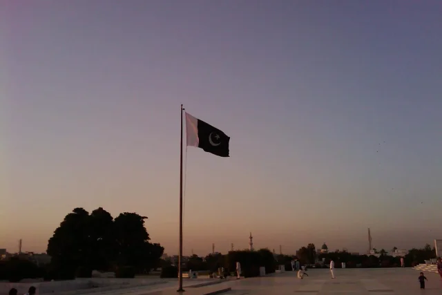 The national flag of Pakistan flying at Mazar-e-Quaid in Karachi at dusk